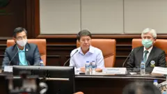 ผู้ชายนั่งแถลงข่าวสามคน