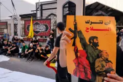 لافتة يرفعها أحد المشاركين في مسيرة لحزب الله تقول العبارة المكتوبة عليها لن نترك السلاح في وقت تتصاعد فيه الضغزط الأمريكية وضغوط أطراف سياسية داخلية على الحزب للتخلي عن سلاحه.