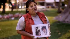Rosa Rojas muestra una foto de su hijo y su marido. muertos en Barrios Altos.