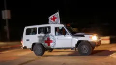 A Red Cross vehicle, as part of a convoy believed to be carrying hostages abducted by Hamas militants during the October 7 attack on Israel, arrives at the Rafah border, amid a hostages-prisoners swap deal between Hamas and Israel, in southern Gaza Strip November 24, 2023.