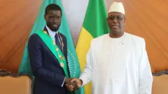 Bassirou Diomaye Faye et Macky Sall qui se serrent la main