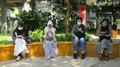 Sekelompok orang membaca di taman