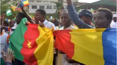 People dey street with Cameroon flag.