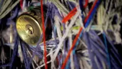Una cerradura se ve por entre hebras de lana