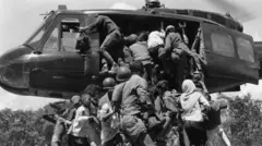 Civis desesperados tentam subir em um helicóptero para escapar de An Loc