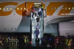 Momento em que deportados venezuelanos descem de um avião da Conviasa.