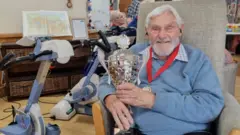 Kenneth Judd with his medal and trophy
