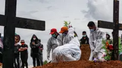 Des personnes en EPI enterrent les victimes du Covid en Indonésie
