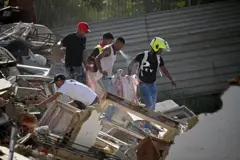 رجال ينقلون جثماناً عبر أنقاض مبنى انهار جراء الزلزالين في مدينة كاتيا لا مار بولاية لا غوايرا، على بُعد نحو 30 كيلومتراً شمال غربي العاصمة كاراكاس، في 25 يونيو/حزيران 2026