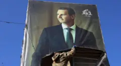 Suriye'de Beşar Esad'ın posterleri binalardan indiriliyor