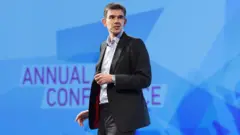 Matt Brittin falando durante uma conferência. Ele está em pé.