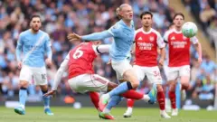 Erling Haaland dey run afta ball in di middlw of Arsenal players