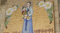 Imagem feita em pastilhas de Maria segurando o menino Jesus no colo na basílica da Anunciação, em Israel. Maria e Jesus têm os olhos puxados, na representação com origem na Coreia do Sul