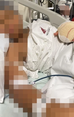 José na maca do hospital. O rosto dele está borrado