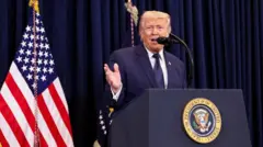 紺の幕と星条旗などを背に、大統領印のついた演台を前にマイクに向かって話す紺色スーツ姿のトランプ氏