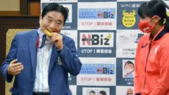 Mayor Takashi Kawamura chomps on Miu Goto's gold