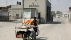 طفل فلسطيني يعمل بائعاً على عربة متنقلة على معبر كرم أبو سالم في قطاع غزة