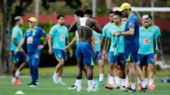 Treino da seleção brasileira de futebol, com um jogador sem camisa, vestindo seu colete inteligente