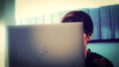 ల్యాప్‌టాప్ స్క్రీన్ ముందు కూర్చున్న మహిళ