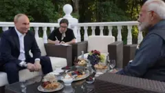 بوتين ومودي في اجتماع على طاولة في شرفة حولها أشجار وعلى الطاولة مأكولات خفيفة وفواكه.