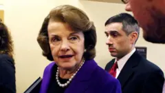 FILE PHOTO: U.S. Senator Dianne Feinstein (D-CA) (C) talks to reporters as she walks to the Senate floor on Capitol Hill, in Washington December 9, 2014.