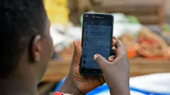 Un homme regqrde ses messages sur Whatsapp