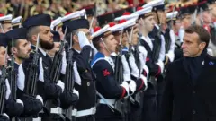 French President Emmanuel Macron reviews troops