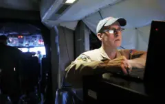 Um especialista da Nasa olhando para a tela do computador em um avião antes da decolagem da Base Aérea de Pituffik