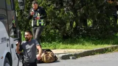 ماموران پلیس بالای سر مهاجمی که روی زمین افتاده است ایستاده‌اند، استانبول، ۷ آوریل ۲۰۲۶ 