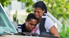 Un hombre y una mujer se abrazan llorando tras los terremotos. 