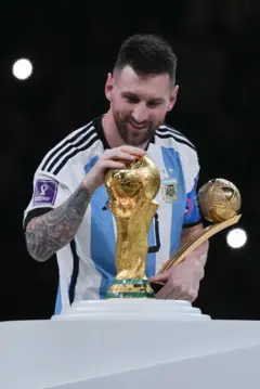 Lionel Messi acariciando o troféu da Copa do Mundo após a final da Copa de 2022, no Catar
