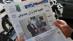 رجل يقرأ صحيفة بينما تحظى الجولة الثانية من المفاوضات غير المباشرة بين إيران والولايات المتحدة في جنيف بتغطية واسعة في الصحف الإيرانية في 17 فبراير/شباط 2026 في طهران، إيران. 