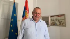 Srđan Milivojević u sedištu Demokratske stranke u centru Beograda sa zastavama Srbije i Evropske unije