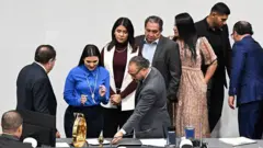 Alexia Rivas (2nd L), deputy of Nuevas Ideas, signs the constitutional reform to approve the life sentence alongside the president of the Congress of El Salvador and member of the ruling party, Ernesto Castro (4th L), in San Salvador on March 17, 2026. (Photo by Marvin RECINOS / AFP via Getty Images)