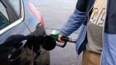 A man filling up his car at a filling station