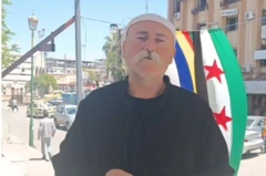  الشيخ ماهر فلحوط، أحد شيوخ الدروز في سوريا، ويظهر فلحوط في الصورة، مرتدياً قميصاً أسود، وطاقية بيضاء ويعلو وجهه شارب أبيض كثيف.