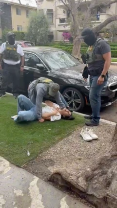 Marjan yace en el piso frente a su casa mientras tres agentes de migración la rodean.