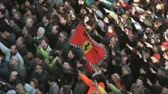 Bandeira da Ferrari no meio de uma multidão protestando na Sérvia em 1997.