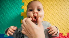 بچے کے گال کو بھینچتے ہوئے