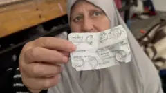 Siham holding out her medication