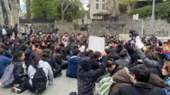 Öğrenciler pankartlarla oturuyor