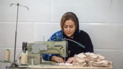 One Iranian woman wey dey work as seamstress for one lingerie factory for Tehran