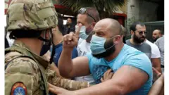 صورة أرشيفية لمتظاهر لبناني يواجه عسكريا