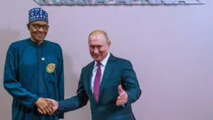 Nigeria President and Russia President Vladimir Putin dey shake hand for dia tok-tok for Sochi