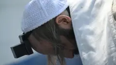 Membro da Lev Tahor reza no lado de fora de um dos centros de acolhida de menores resgatados pelo Estado da Guatemala