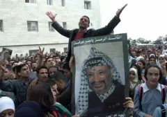 Manifestants tenant la photo de Yasser Arafat.