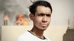 Alí Hussein Julood, joven de 19 años de Rumaila frente a una quema de gas.