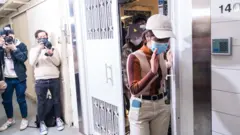 香港觀塘《立場新聞》辦公室外記者拍攝幾名《立場》職員離開（29/12/2021）