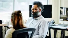 Male colleague looks at a female colleague