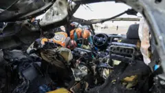 Palestinos inspeccionan el lugar donde un ataque israelí alcanzó un coche en la ciudad de Gaza, el 13 de diciembre de 2025.